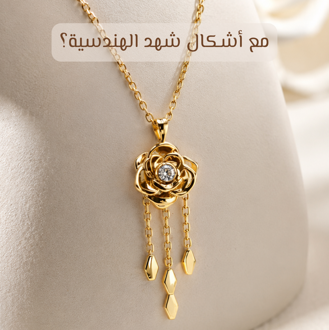 Gold rose pendant necklace with dangling teardrop charms and a clear center stone, displayed on a cream jewelry bust. Arabic text appears at the top.